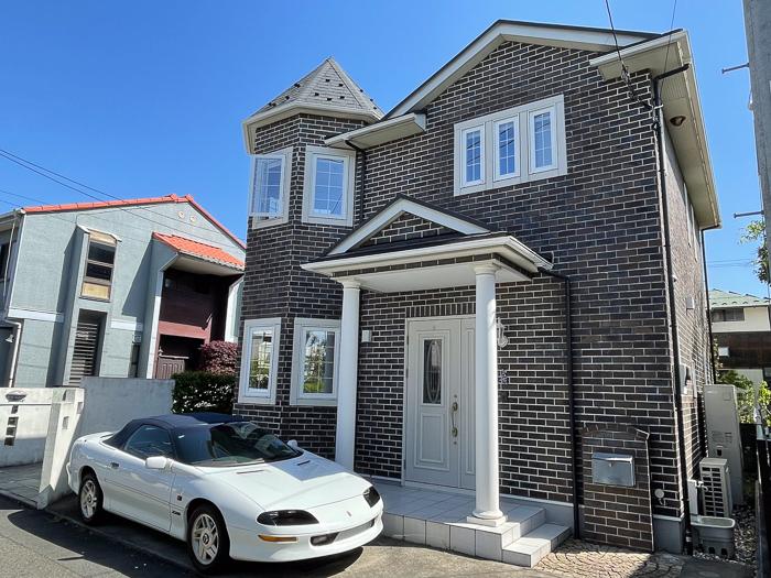 茅ヶ崎市東海岸一丁目の賃貸物件/こげ茶の煉瓦の外壁に、八角形の塔屋。白い窓枠とカバードポーチがやわらかく縁取り、どこかノスタルジックな雰囲気をまとっています