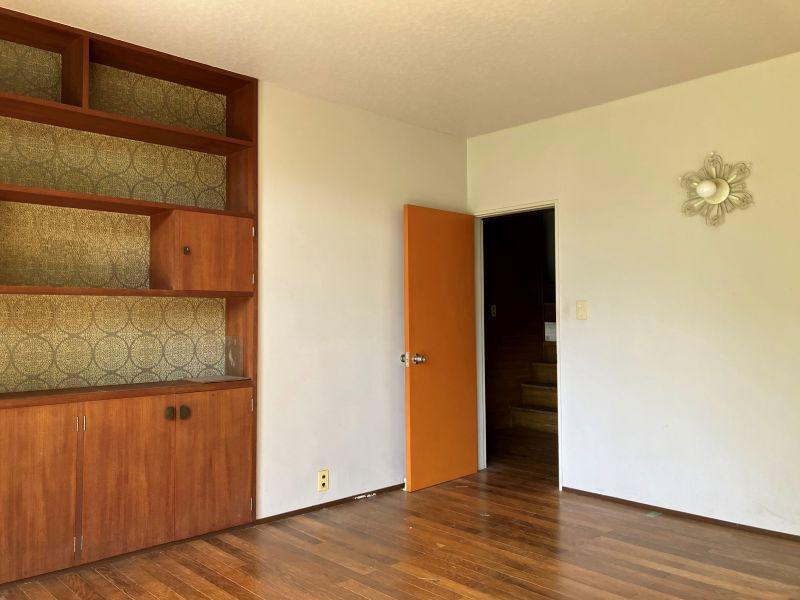 鎌倉市浄明寺四丁目の売買物件/リビング｜造り付け収納と、オレンジの扉と、白い花みたいな照明。