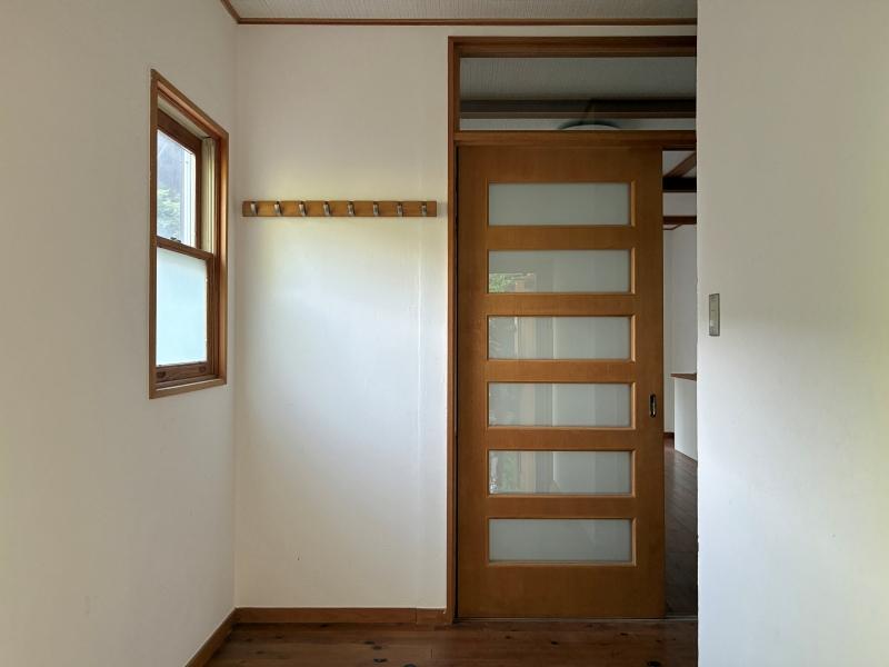 鎌倉市極楽寺三丁目の賃貸物件/玄関｜木製建具と白い塗装の壁がお出迎え