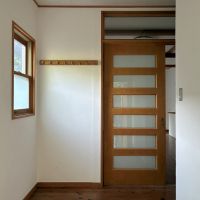 鎌倉市極楽寺三丁目の賃貸物件/玄関｜木製建具と白い塗装の壁がお出迎え