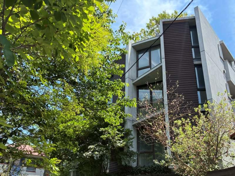 藤沢市片瀬四丁目の賃貸物件/コンクリートと板張りの外壁が印象的。敷地内には植物がたっぷりと植えられ、まるで建物が深緑に包まれているよう