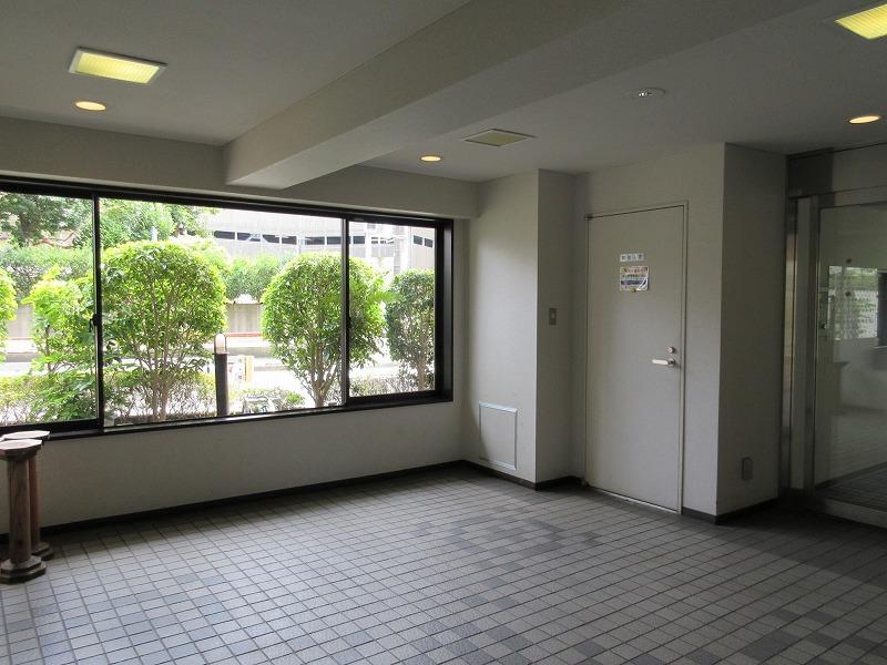 マンションのエントランス部分。管理人さんがいて共用部の掃除などをしてくれている