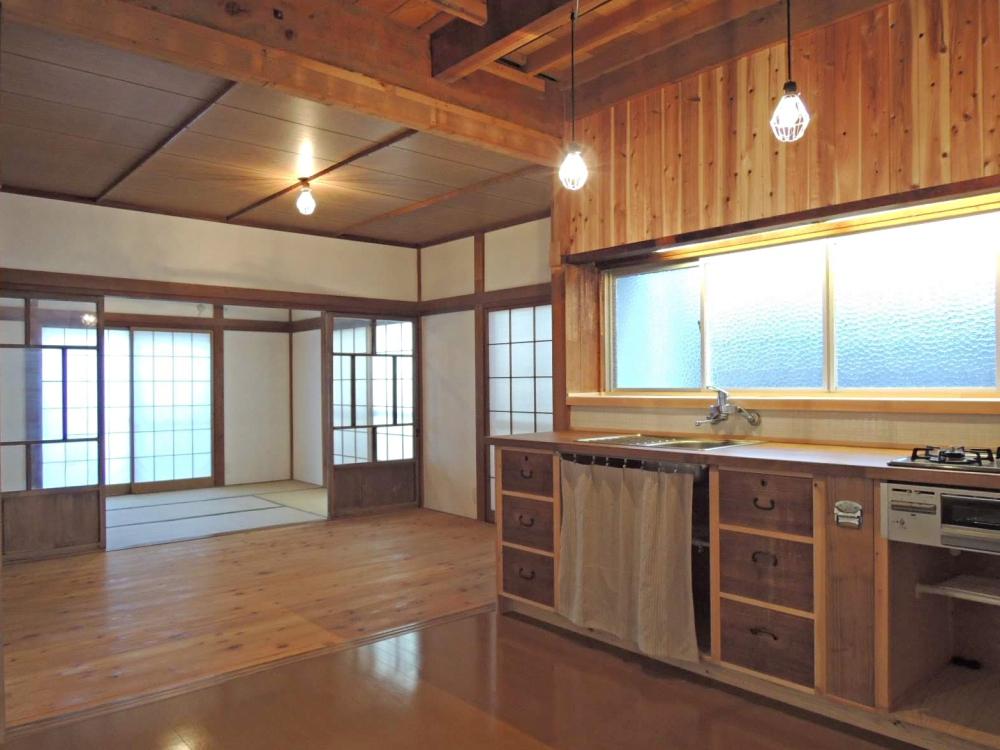 手前からLDKから和室までひとつながりに。木のキッチンの正面壁には白い小さなタイルが貼られています。