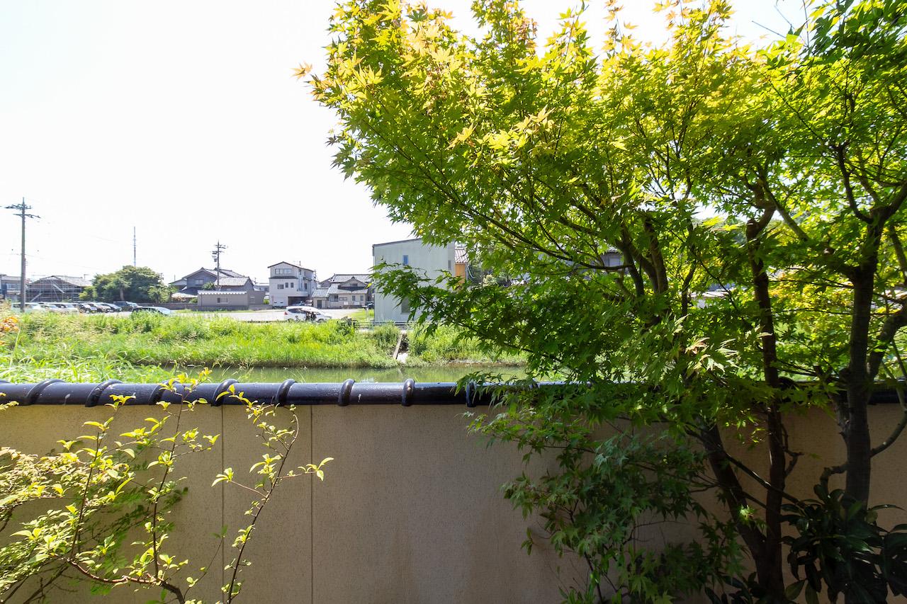 金沢市金石本町の売買物件/客間の縁側からの眺望。目の前は川です。川の向こうは近くの幼稚園の駐車場になっているので抜けがあり、時間によっては園児の姿も。川を覗けば、鳥たちも。緩やかな時間が流れます。