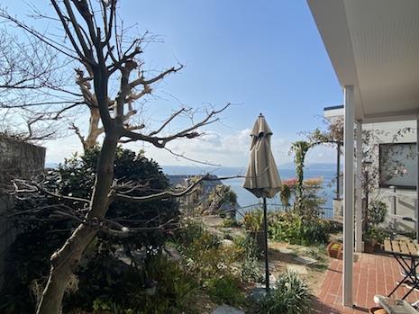 神戸市垂水区塩屋町の売買物件/2階上段の庭。木々の狭間から海。