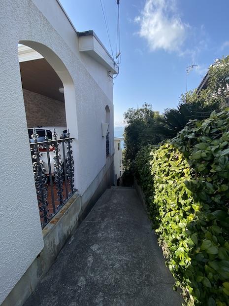 神戸市垂水区塩屋町の売買物件/家の脇、階段状の路地から海が見える。