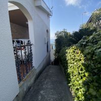 神戸市垂水区塩屋町の売買物件/家の脇、階段状の路地から海が見える。