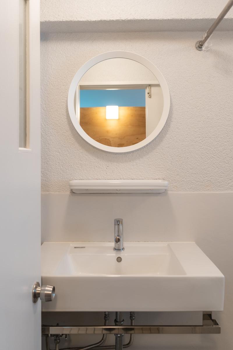 尼崎市道意町の賃貸物件/ミニマルな洗面は丸い鏡がチャームポイント