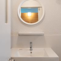尼崎市道意町の賃貸物件/ミニマルな洗面は丸い鏡がチャームポイント