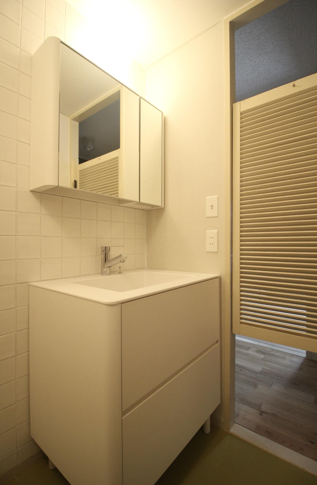 芦屋市楠町の賃貸物件/丸みを帯びたマットな洗面台と、ルーバーのウエスタンドア。