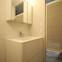 芦屋市楠町の賃貸物件/丸みを帯びたマットな洗面台と、ルーバーのウエスタンドア。