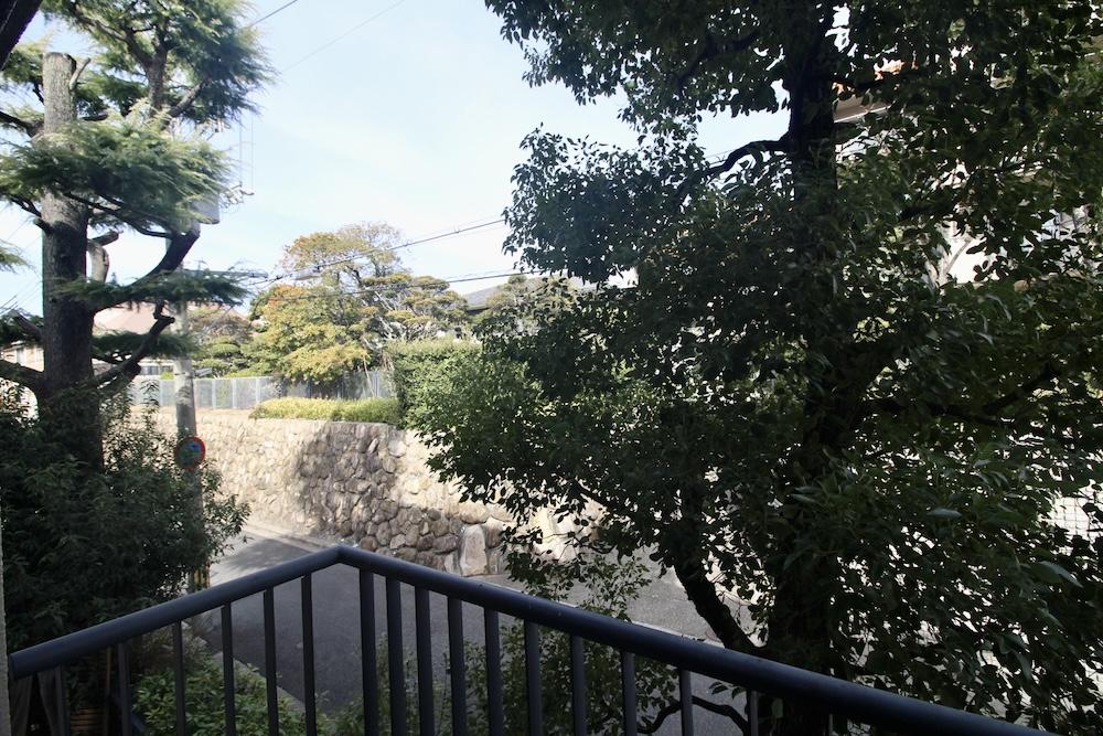 芦屋市楠町の賃貸物件/LDKの開き窓の先に、木々と石垣の街並み。