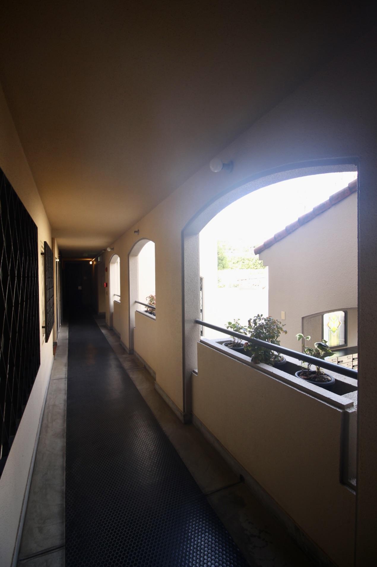 芦屋市楠町の賃貸物件/アールの開口と、タイル床の共用廊下。