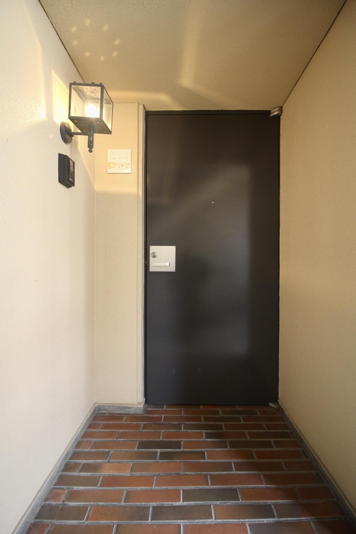 芦屋市楠町の賃貸物件/玄関のレトロ照明と、煉瓦タイル。