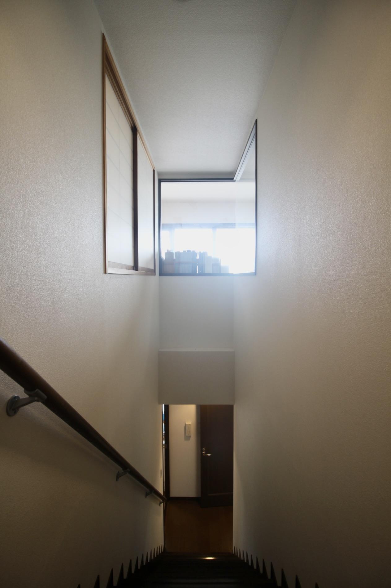 西宮市桜町の売買物件/リビングのコーナーガラスから光が差し込む階段。ゆとりある幅も魅力。