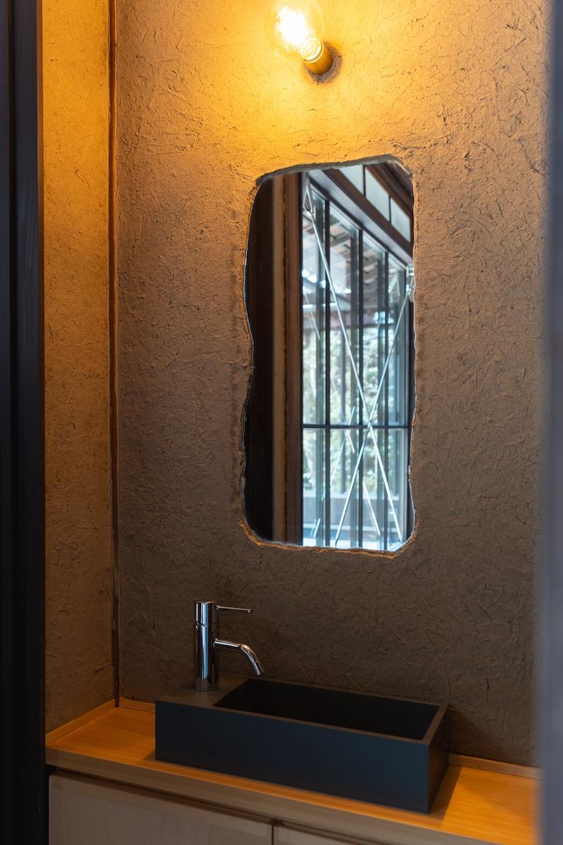 三田市三田町の賃貸物件/土壁に鏡が埋め込まれた洗面所