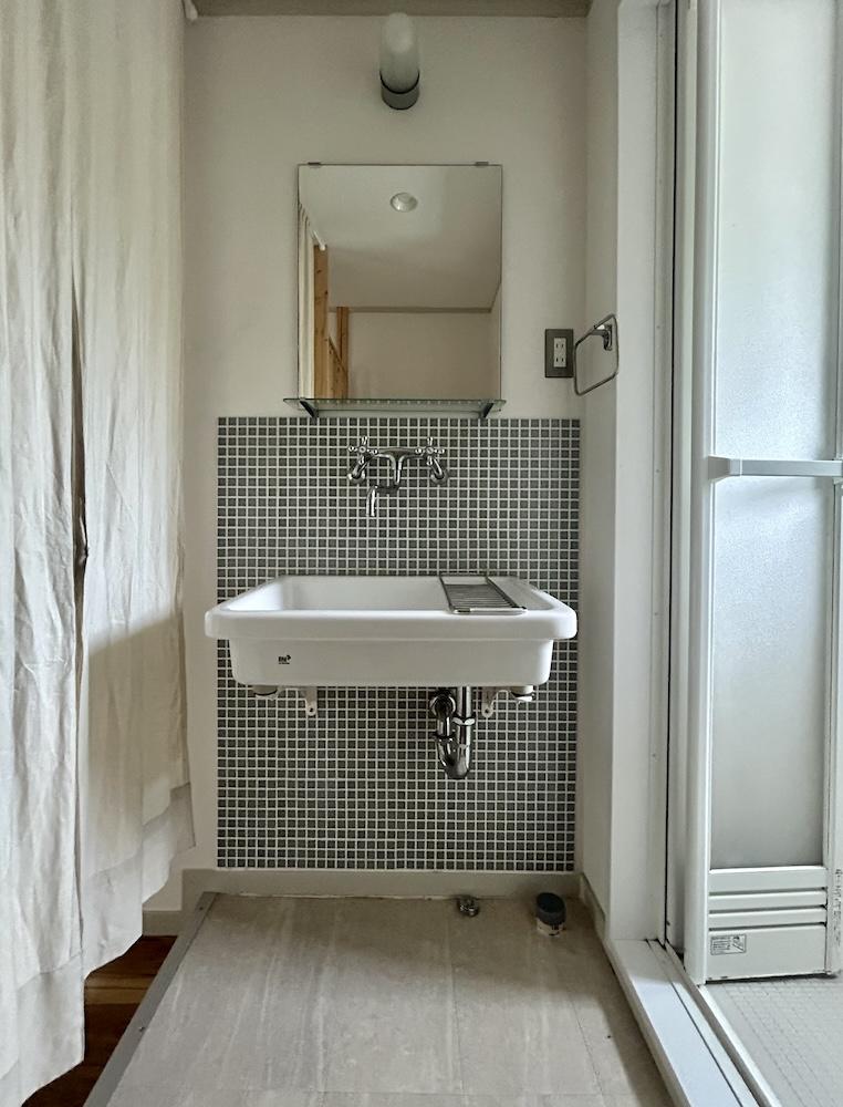 神戸市須磨区高倉台の売買物件/洗面所はシンプルな露出配管のシンクとタイル