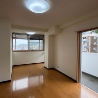 神戸市東灘区本山北町の賃貸物件/北西の洋室。奥の窓から見えるのは山手らしい傾斜のついた住宅街。