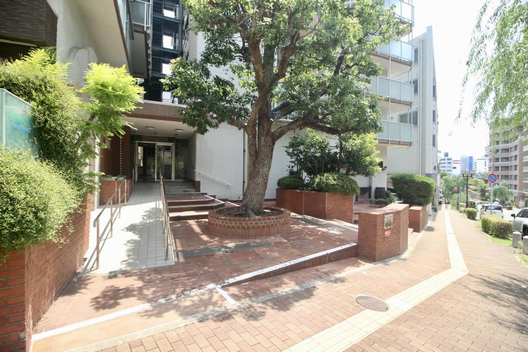 神戸市中央区下山手通の売買物件/煉瓦タイル敷きのエントランスに、シンボルツリーがお出迎え。1階には名店バーも。