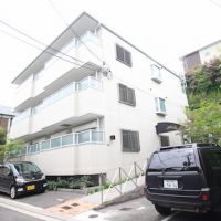 宝塚市野上の賃貸物件/白タイルのシンプルな外観と緑の庭