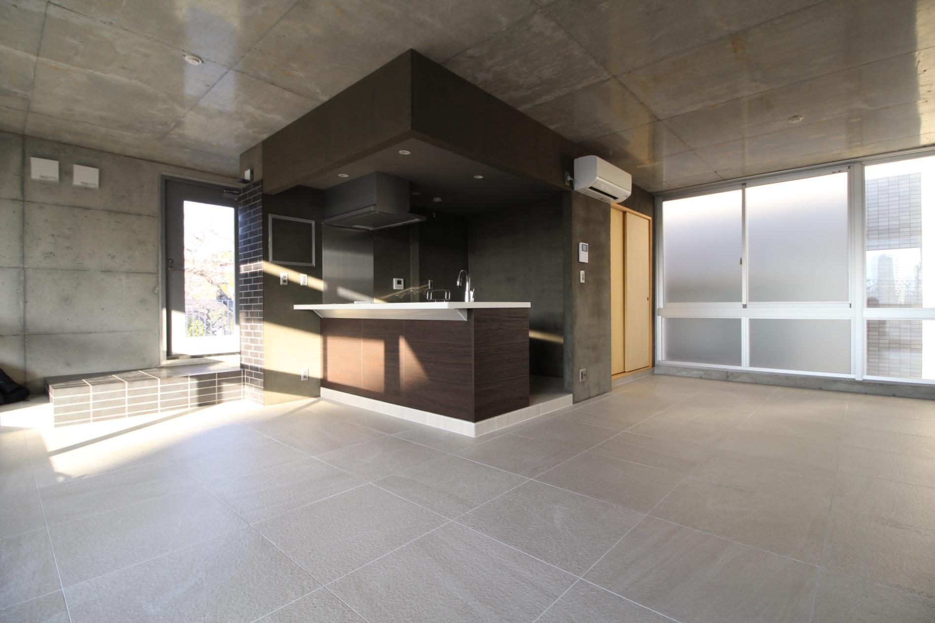 西宮市松原町の賃貸物件/無機質ながら表情のある素材を多用し、建具は木製であたたかみも感じる