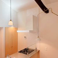 京都市北区紫野今宮町の賃貸物件/キッチン。冷蔵庫はニッチに収納するのでスマートに納まります。扉付き収納もあるので余計なものはLDKに出さずに済みます。意匠照明はFLAMEで揃えて暖かい雰囲気に