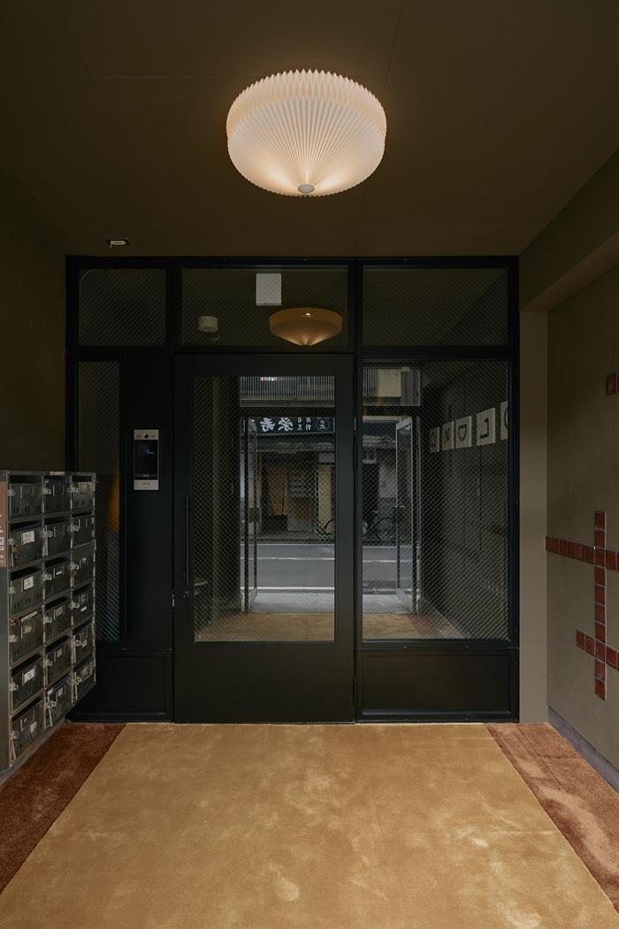 京都市右京区嵯峨中通町13-36の賃貸物件/ふかかふかの絨毯から研ぎ出しの床へ続くエントランス