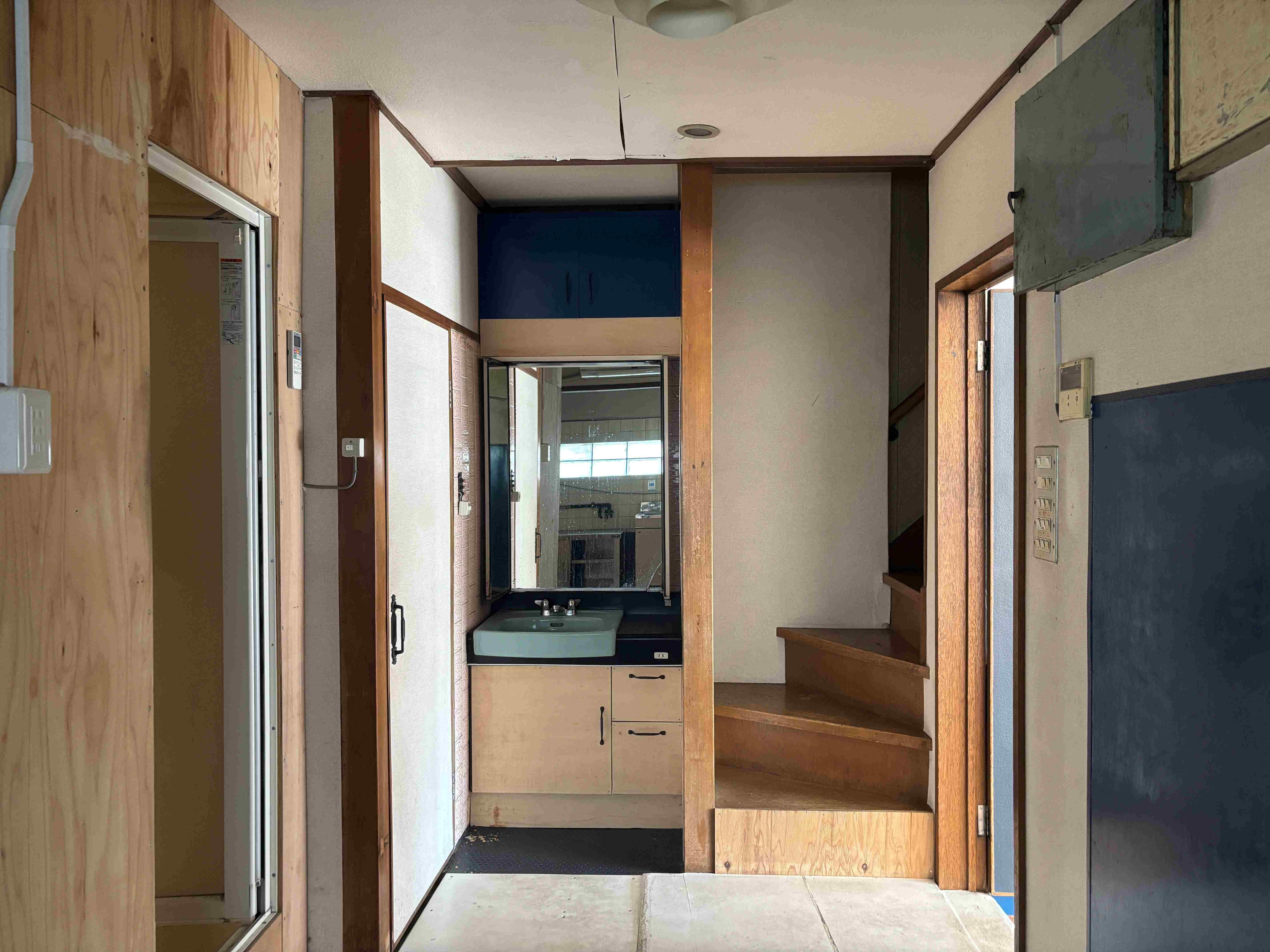 京都市北区紫竹西桃ノ本町５の賃貸物件/正面には洗面台と階段、右手方向に店舗の扉、左手方向には風呂とトイレ