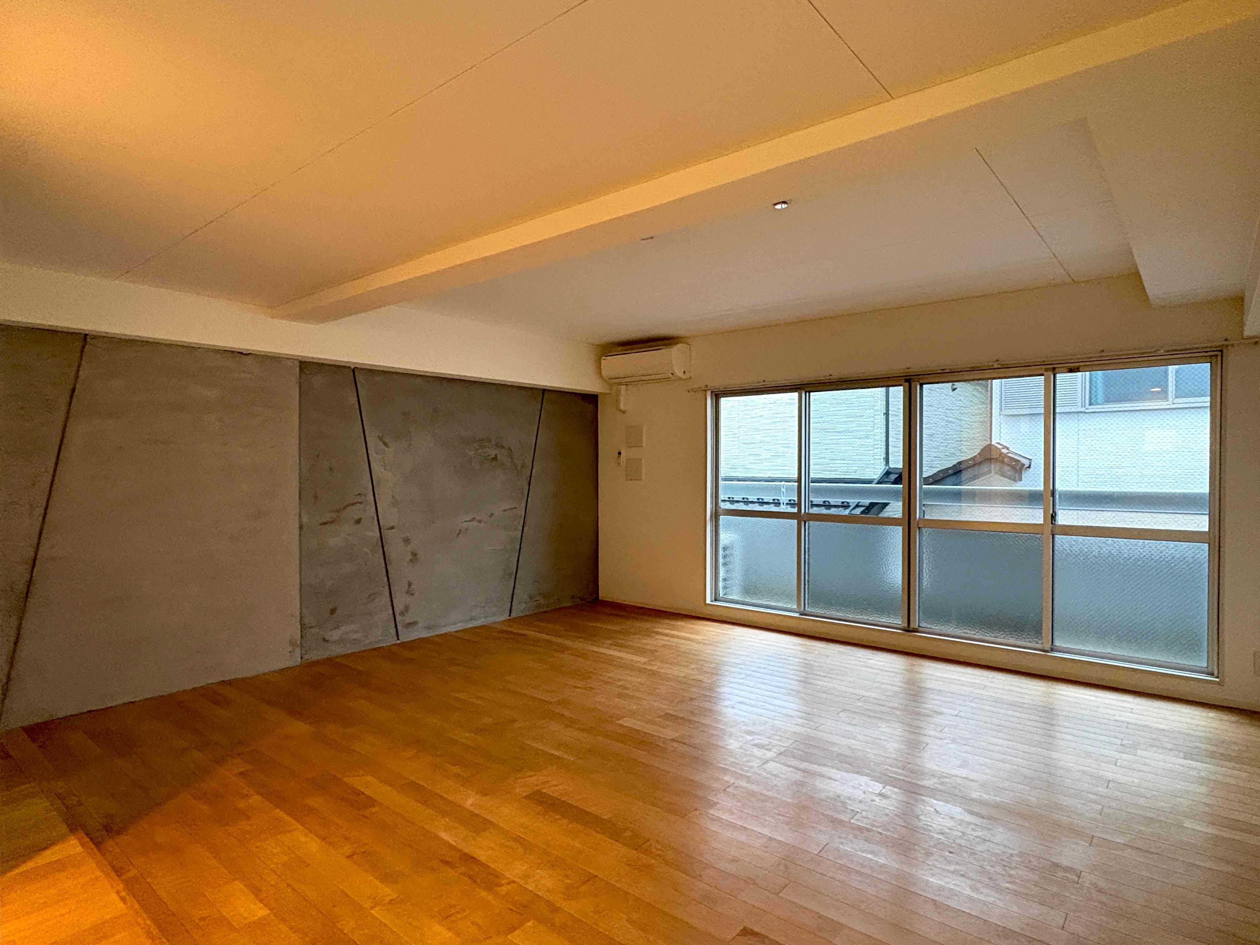 京都市北区紫野西泉堂町42-1の賃貸物件/一面がモルタル仕上げの壁になっていて、広がる無垢材を使用した床。