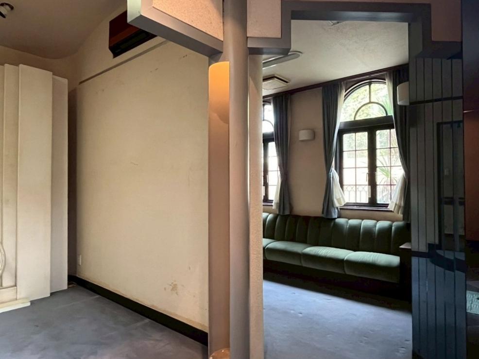 京都市北区紫竹上長目町25-1の売買物件/ソファーのある洋室を介して東側のメイン玄関と北側の勝手口へと行き来できる。