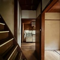 京都市山科区日ノ岡夷谷町21-9の売買物件/玄関間階段越しに台所。階段が廊下まで張り出していても急勾配。ここはちょっと手直ししたいところです