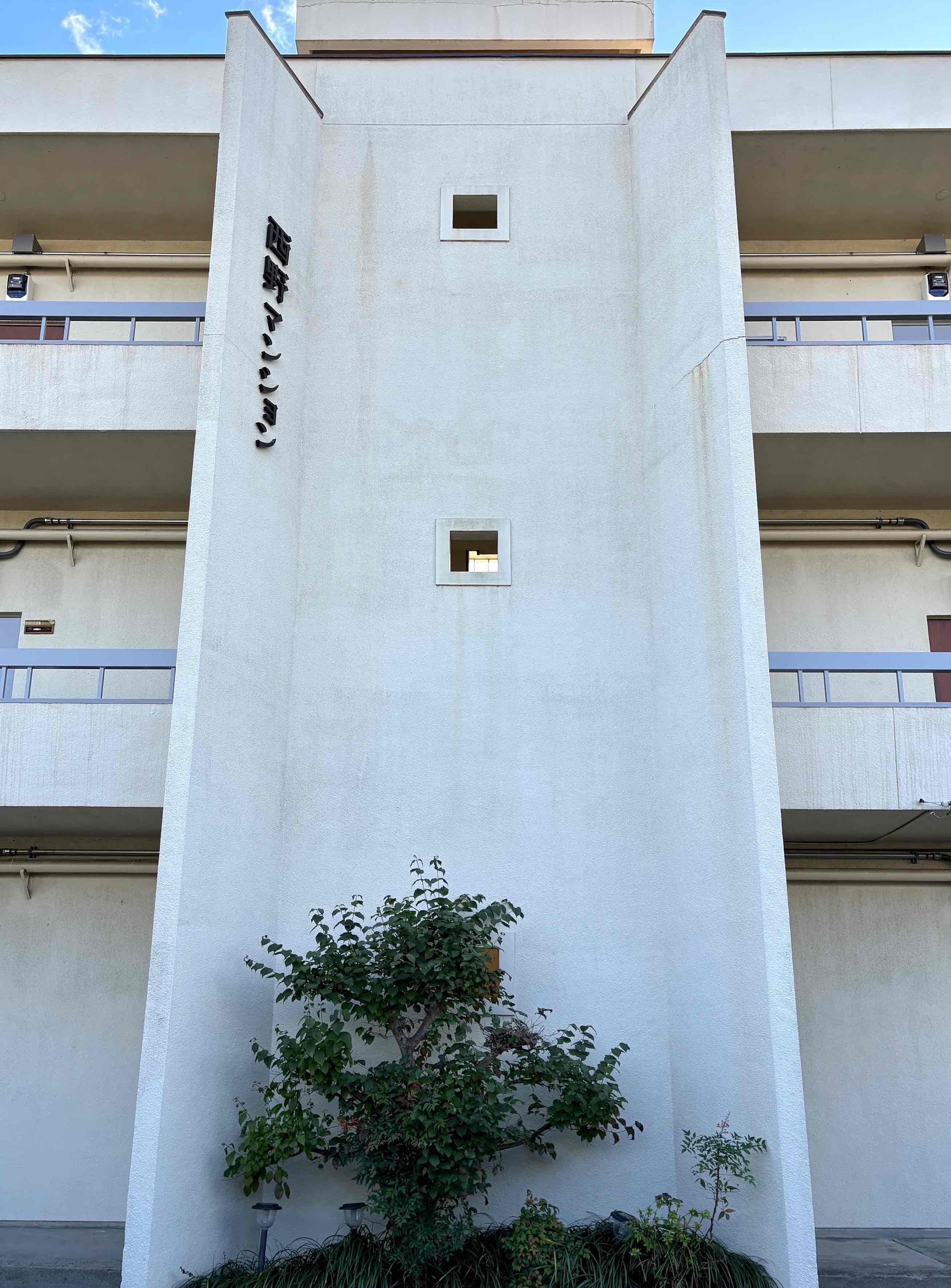 京都市山科区西野岸ノ下町60の賃貸物件/重厚感を感じる建物中央の垂直壁。階段の目隠しの役目も果たすトレードマーク