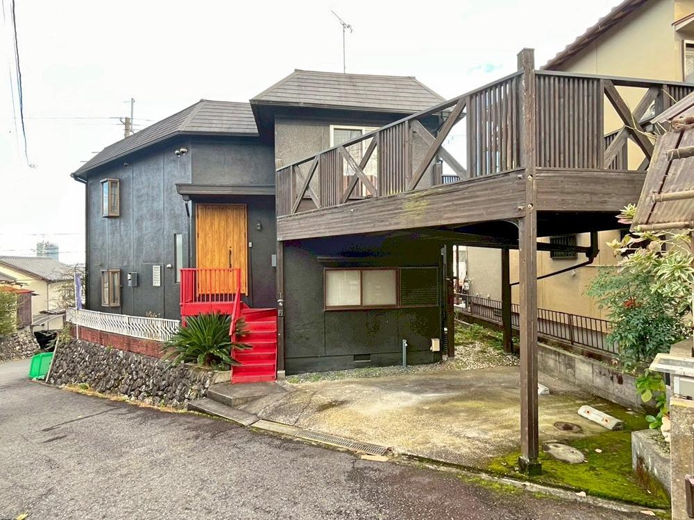 滋賀県大津市本宮二丁目の売買物件/船首のように伸びるウッドデッキと鉄階段のビビットな赤が印象的。