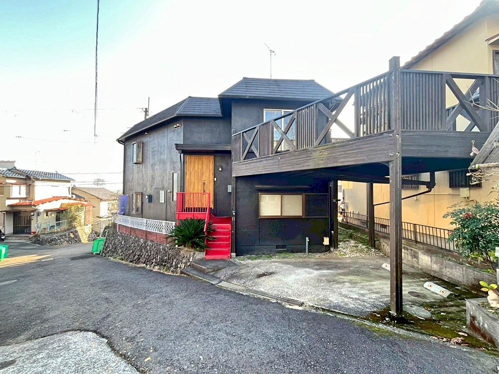 滋賀県大津市本宮二丁目の売買物件/船首のように伸びるウッドデッキと鉄階段のビビットな赤が印象的。