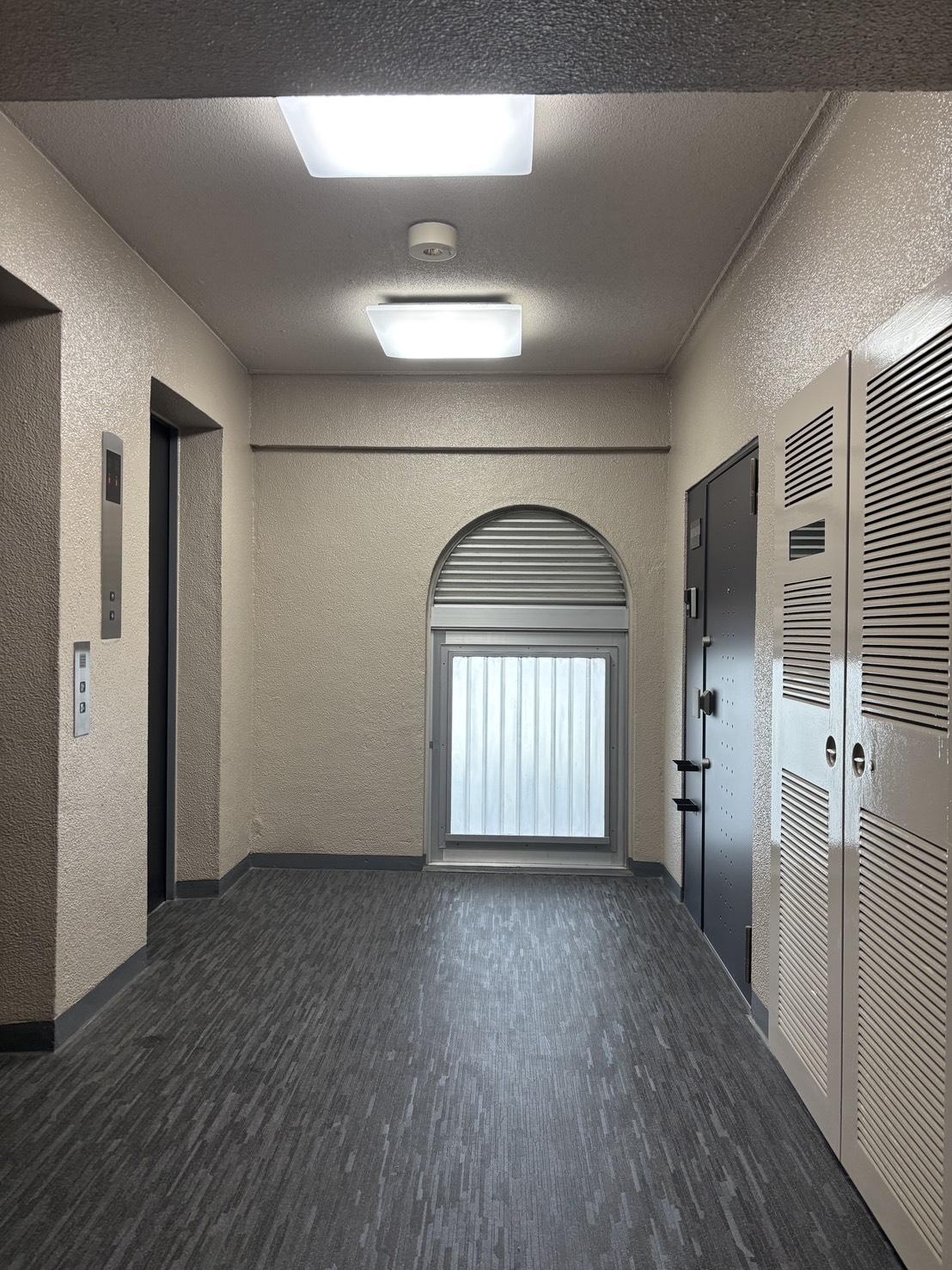 京都市上京区中立売通室町西入三丁町471の売買物件/2基のエレベーター前、共用部の窓の意匠も印象的