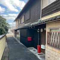 滋賀県大津市尾花川9-18の売買物件/該当物件は4連棟の真ん中。路地を抜けると近隣店舗の駐車場へ続いている。