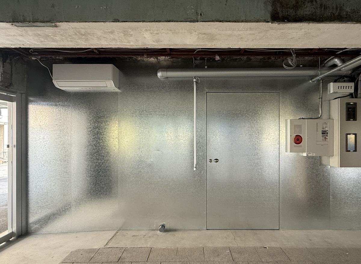 京都市下京区朱雀宝蔵町56の賃貸物件/1階テナント部分入口。共用部分には亜鉛メッキ鋼板を採用。既存のハードな雰囲気とのコントラストがとてもいい雰囲気