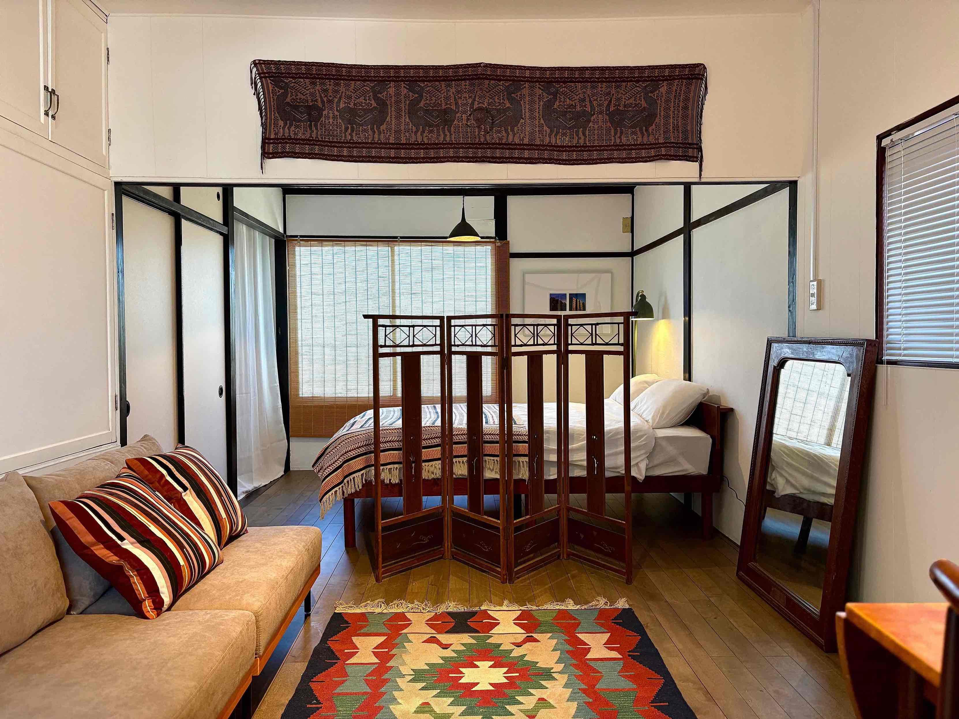 京都市北区紫竹高縄町の賃貸物件/手前の右に2人掛けのデスク、奥にはベッドと緩やかに空間が区切られています