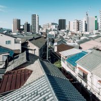 大阪市福島区海老江７丁目の賃貸物件/手前は長屋群の屋根瓦、奥は高層マンションやビル。街の歴史が垣間見える、このエリアならではの眺め。