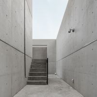 奈良県生駒市の賃貸物件/建物と敷地外周を囲む高い壁との間を通って中庭に