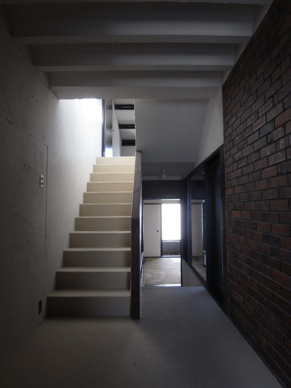 寝屋川市成田南町の賃貸物件/躯体現し白塗装の天井と壁に、一部煉瓦貼のアクセントウォール