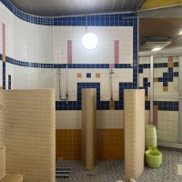 大阪市福島区福島5丁目の賃貸物件/オレンジ・青・黄色の幾何学模様タイルに囲まれた洗い場。