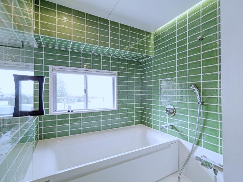 大阪府豊中市上新田４丁目の賃貸物件/浴室はゆとりある1616サイズ。壁面いっぱいに敷き詰められたグリーンのタイルはガラス越しにLDKのインテリアにも。