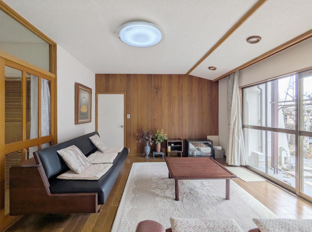 堺市南区原山台4丁の売買物件/銘木合板が壁一面に設えられたリビング。