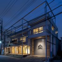 横浜市都筑区池辺町の賃貸物件/夜は照明で建物が浮かび上がります、シャッターにペイントされた桃と山の企業ロゴがライトアップされ目立っています