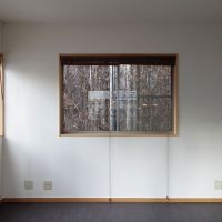 港区西麻布の賃貸物件/2階の北側の窓。ツタに覆われた隣の建物が見えるので、ツタに葉がつけば緑が見えるかも