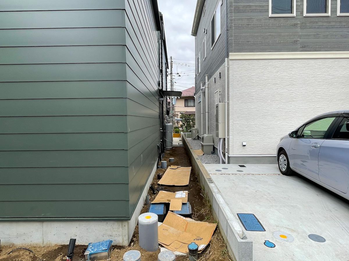 川崎市多摩区栗谷の賃貸物件/玄関は建物右側に。建築時の写真のため未完成ですが、現在は玄関までのアプローチはコンクリート敷き