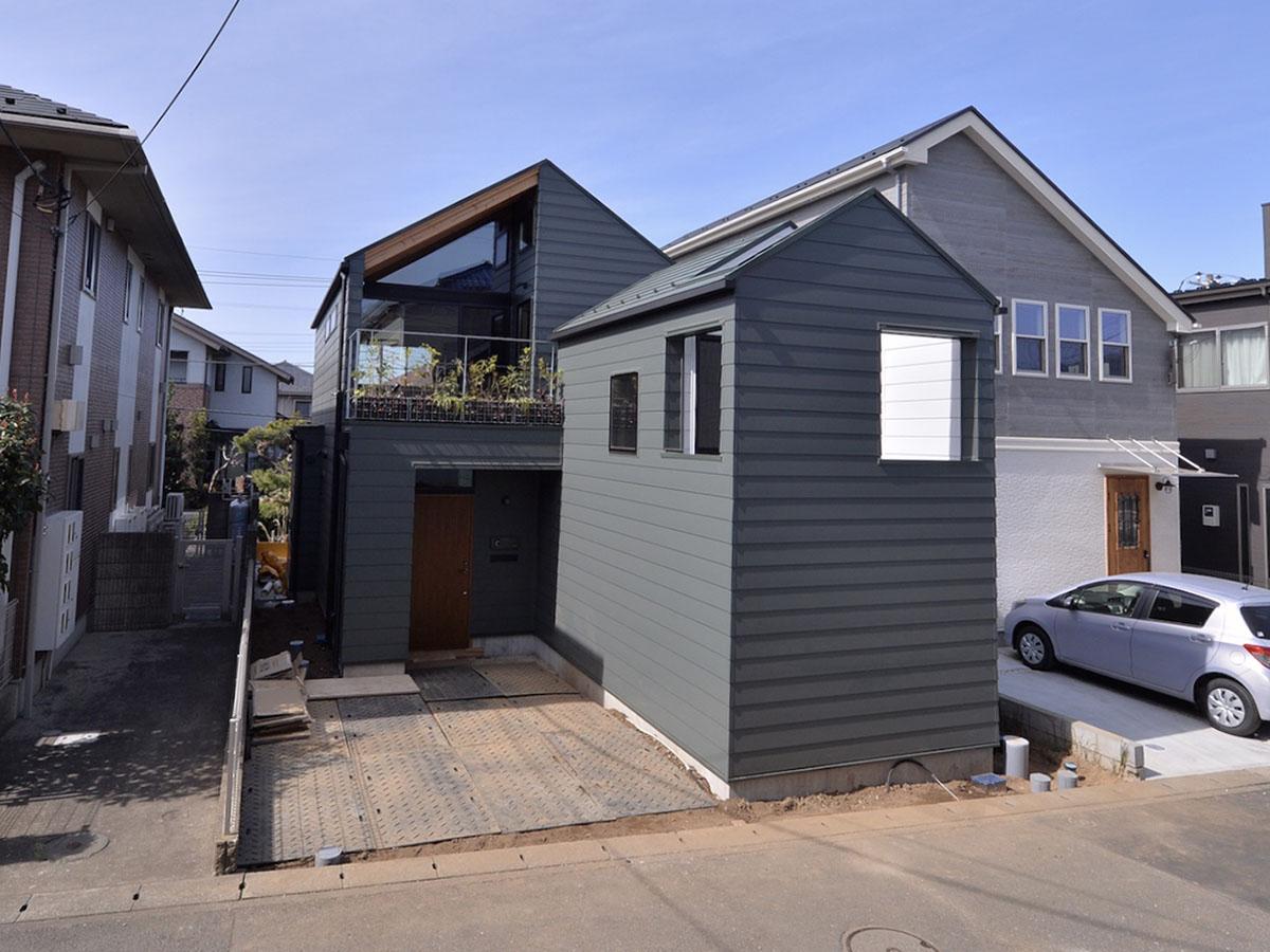 川崎市多摩区栗谷の賃貸物件/緑の外観が街に馴染んだ、すてきな戸建て。右側の突き出た山小屋のような部分が今回の賃貸部分です