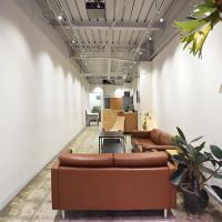 中央区日本橋横山町の賃貸物件/建物1階にあるレンタルスペース。ソファやテーブル、プロジェクターやスクリーンが置かれている