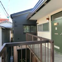 八王子市天神町の賃貸物件/グリーンの扉がかわいい玄関、黒壁の母屋はすぐとなりです